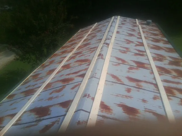 Rusted metal roof panels with new wood purlins before replacement — Storm Damage Roof Repair in Haskins by Roofing Brothers