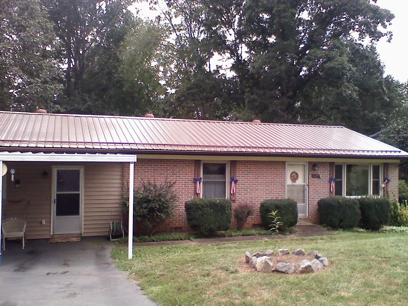 Bronze metal roof and carport on a brick ranch home — Roof Repair work by our crew in Haskins